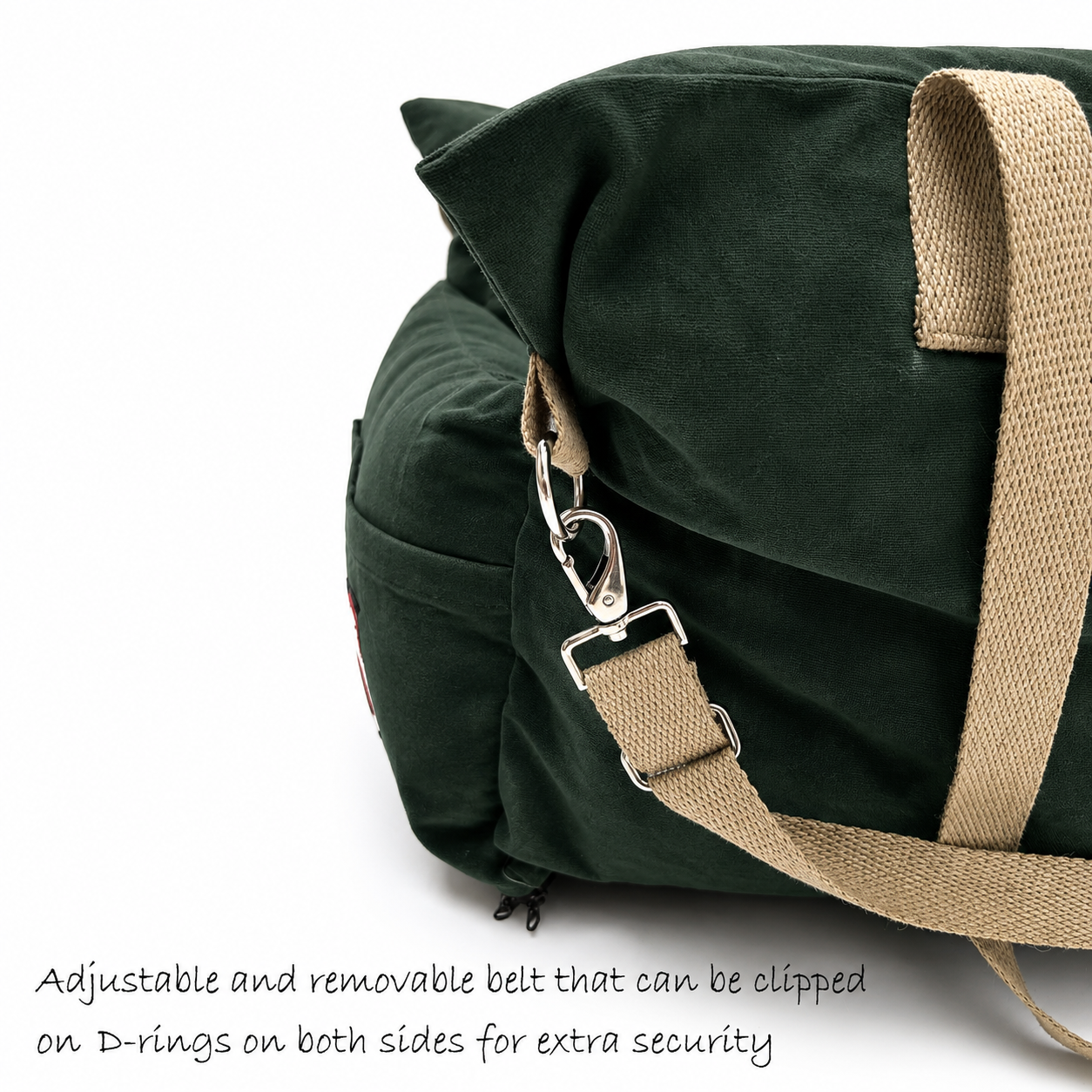 Dark green canvas dog travel bed with beige webbing straps and silver metal clips, shown on a white background with text describing the adjustable and removable belt.